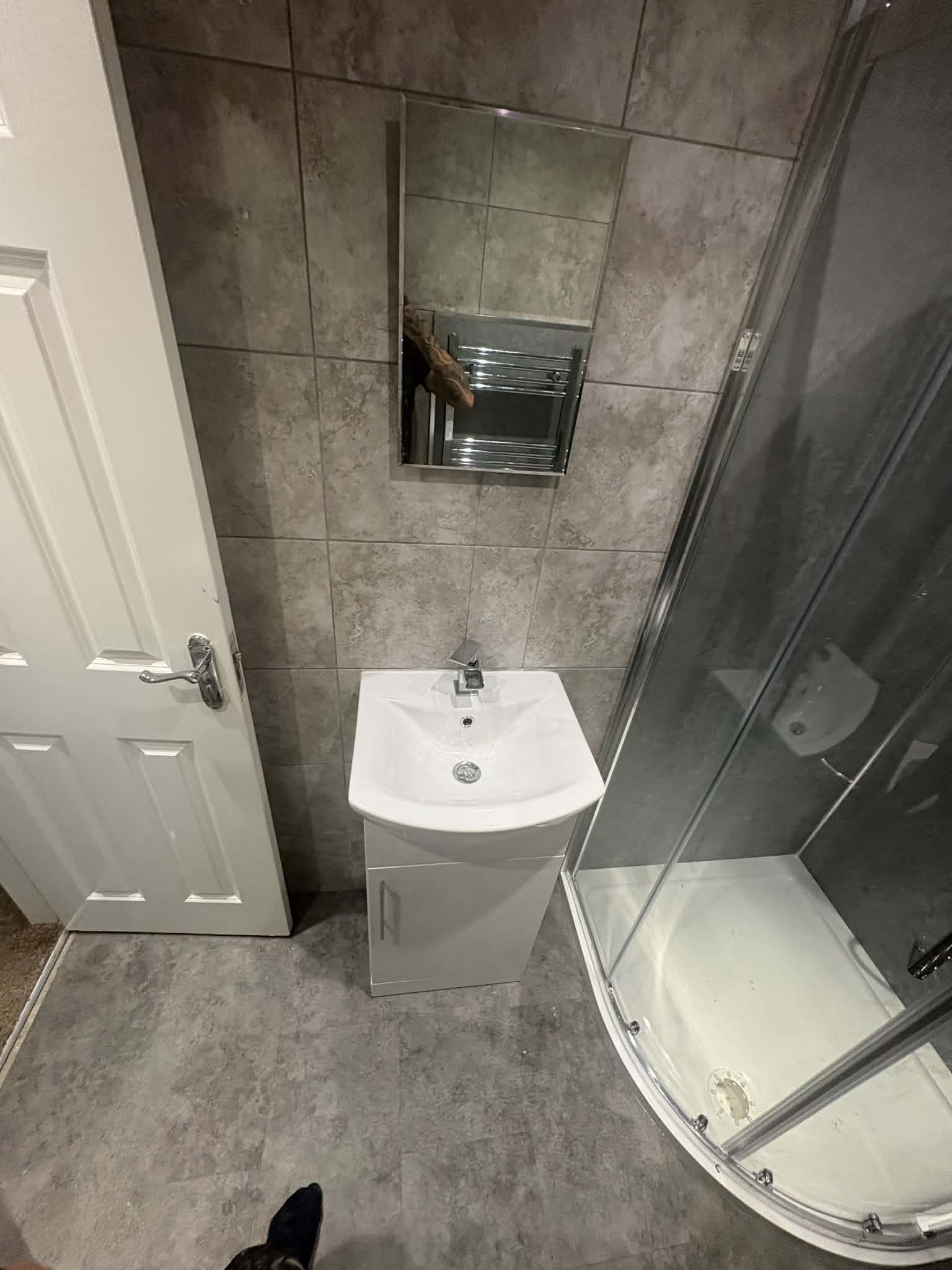 Grey-tile bathroom with quadrant shower in Gosforth